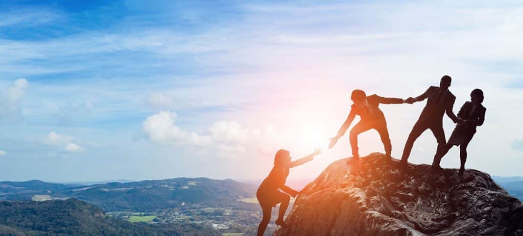 Success manager helping people up a hill